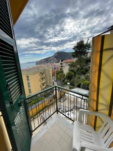 een balkon met een stoel en uitzicht op de stad bij Hotel Deutsche Familien in Finale Ligure