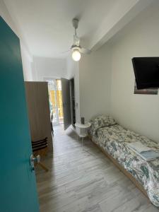 a room with a bed and a television in it at Hotel Deutsche Familien in Finale Ligure