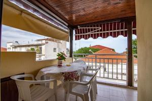a table and chairs on a balcony with a view at Villa Evelin in Asprovalta