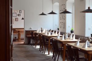 a row of wooden tables and chairs in a room at Genusswerk Krug SB Hotel in Bad Endorf