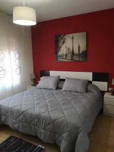 a bedroom with a bed with a red wall at Apartamento duplex vacacional in Arenys de Mar