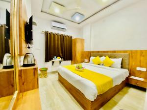 a bedroom with a large bed with a yellow blanket at Hotel Vallabh with lake facing balcony in Udaipur