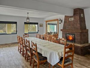 a dining room with a table and a fireplace at Casa Șimon in Leordina
