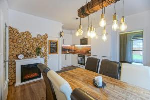 a kitchen and dining room with a table and a fireplace at AusZeit Steiraland 6 mit überdachter Terasse schönen Garten und kostenlosen Parkplatz in Leoben