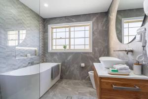 a bathroom with a tub and a toilet and a sink at Aria waterview in Point Clare