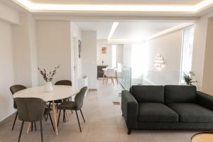 salon z kanapą, stołem i krzesłami w obiekcie Athens Heart Luxury Penthouse w Atenach