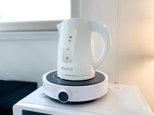 a white electric blender sitting on top of a microwave at Koin Guesthouse Incheon airport in Incheon