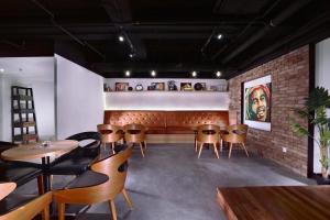 een restaurant met stoelen en tafels en een bakstenen muur bij Neo+ Penang in George Town