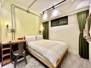 a small bedroom with a bed and a desk at 小鹿 Homestay in Taichung