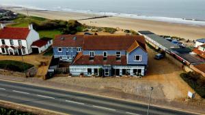a house on the beach next to the ocean at Seals Bacton in Bacton