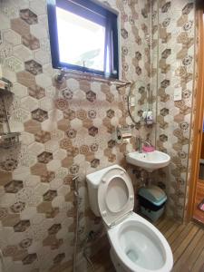 ein Bad mit einem WC, einem Waschbecken und einem Fenster in der Unterkunft Lucas Transient House in Looc