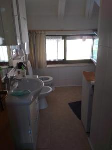 uma casa de banho com um lavatório e um WC em Casa Vio em Calceranica al Lago