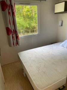 a bedroom with a bed and a window at Camping Le Ruisseau in Saint-André-de-Seignanx +111 photos