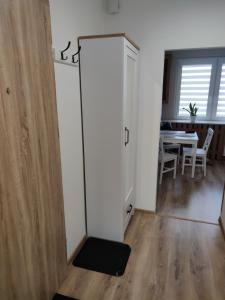 a room with a door and a dining room with a table at APARTAMENT MAGNOLIA in Sandomierz