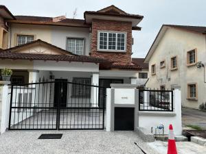 una casa con un cancello nero davanti a una casa di Home in Bandar Baru Bangi a Bandar Baru Bangi