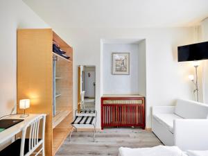 Una sala de estar con un sofá blanco y un radiador rojo. en Hotel San Marco, en Garda