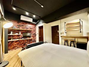 una camera con un letto bianco e un muro di mattoni di 小鹿 Homestay a Taichung