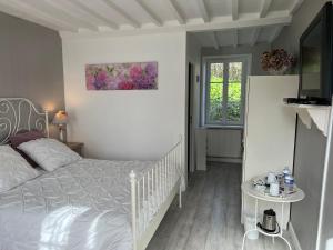 biała sypialnia z łóżkiem i oknem w obiekcie Le Clos Saint Jean w mieście Sainte-Honorine-des-Pertes