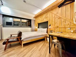 a bedroom with a bed and a desk in it at 小鹿之家 in Taichung