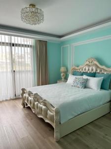 a bedroom with a large bed with blue walls and a chandelier at Star Le in Magong
