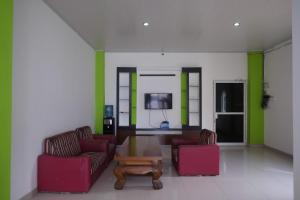 uma sala de estar com duas cadeiras e uma mesa de centro em RedDoorz near Pakuwon Mall Solo Baru em Sukoharjo