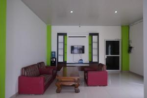 a living room with two chairs and a coffee table at RedDoorz near Pakuwon Mall Solo Baru in Sukoharjo