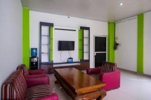a living room with a table and chairs and a tv at RedDoorz near Pakuwon Mall Solo Baru in Sukoharjo