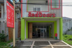 a red door with a sign on a building at RedDoorz near Pakuwon Mall Solo Baru in Sukoharjo +25 photos