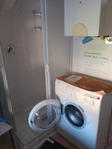 uma máquina de lavar roupa na casa de banho com uma máquina de lavar roupa em Casa Vio em Calceranica al Lago