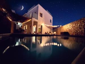 a house with a swimming pool at night at Escape to paradise luxury Poolvilla with ocieanview near Amadores in Mogán