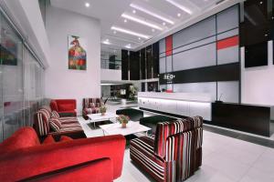 a lobby with red chairs and a table in a building at Neo+ Penang in George Town