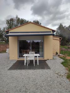 ein kleines Haus mit einem weißen Tisch davor in der Unterkunft Les Gîtes De La Caneda in Sarlat-la-Canéda