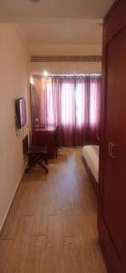 a room with a bedroom with a bed and a desk at Rain Drops Hotel in Chennai