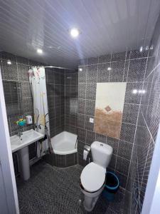 y baño con aseo, lavabo y ducha. en Hotel Guest House GOLDEN DEGREZ en Bukhara