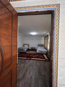 ブハラにあるHotel Guest House GOLDEN DEGREZのベッド2台付きの部屋へとつながるドア