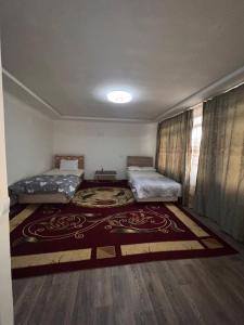 Cette chambre comprend 2 lits et un tapis. dans l'établissement Hotel Guest House GOLDEN DEGREZ, à Boukhara