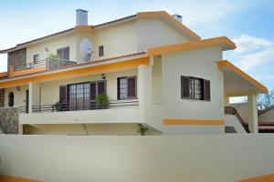 a house with a fence in front of it at Casa Grande Holidays in São Martinho do Porto