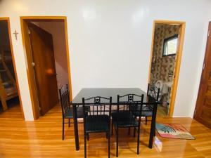 ein schwarzer Esstisch und Stühle in einem Zimmer in der Unterkunft Lucas Transient House in Looc