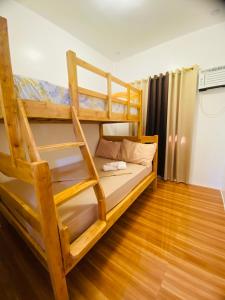 1 Schlafzimmer mit 2 Etagenbetten und Holzboden in der Unterkunft Lucas Transient House in Looc