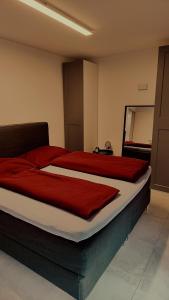 een slaapkamer met een groot bed met rode lakens bij SPA RESIDENZ NEUSIEDL APPARTMENTS in Neusiedl am See