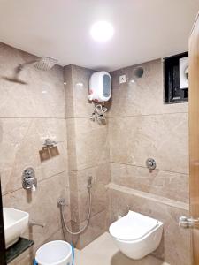 uma casa de banho com um chuveiro, um WC e um lavatório. em Hotel Pratham Inn em Ahmedabad