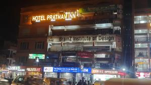 a building with signs on the side of it at night at Hotel Pratham Inn in Ahmedabad