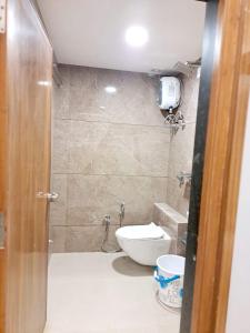a bathroom with a toilet and a sink at Hotel Pratham Inn in Ahmedabad