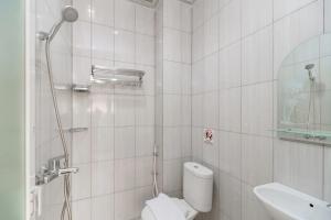 a bathroom with a shower and a toilet and a sink at Urbanview Hotel Gita Inn Bali in Denpasar