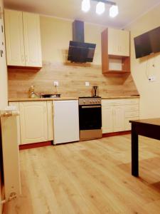 uma cozinha com armários brancos e um forno preto em ChillHouse 2 em Mrągowo