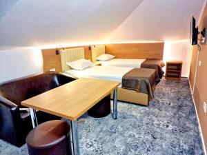 Cette chambre d'hôtel comprend deux lits, une table et des chaises. dans l'établissement Stay Inn Rediu, à Iaşi