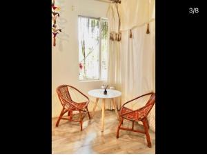 a table and two chairs and a table and a window at Pao's Leisure Homestay in Ha Giang