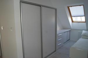eine Glasschiebetür in einem Schlafzimmer mit einem Bett in der Unterkunft Kama Apartament Kamień Pomorski in Cammin in Pommern