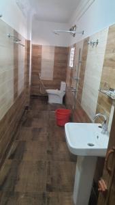 uma casa de banho com um WC, um lavatório e um chuveiro em SANS TEA VILLA em Jalpāiguri