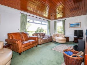 a living room with leather furniture and a television at Trevow in Camborne